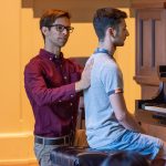 Fixing a student's posture at a piano