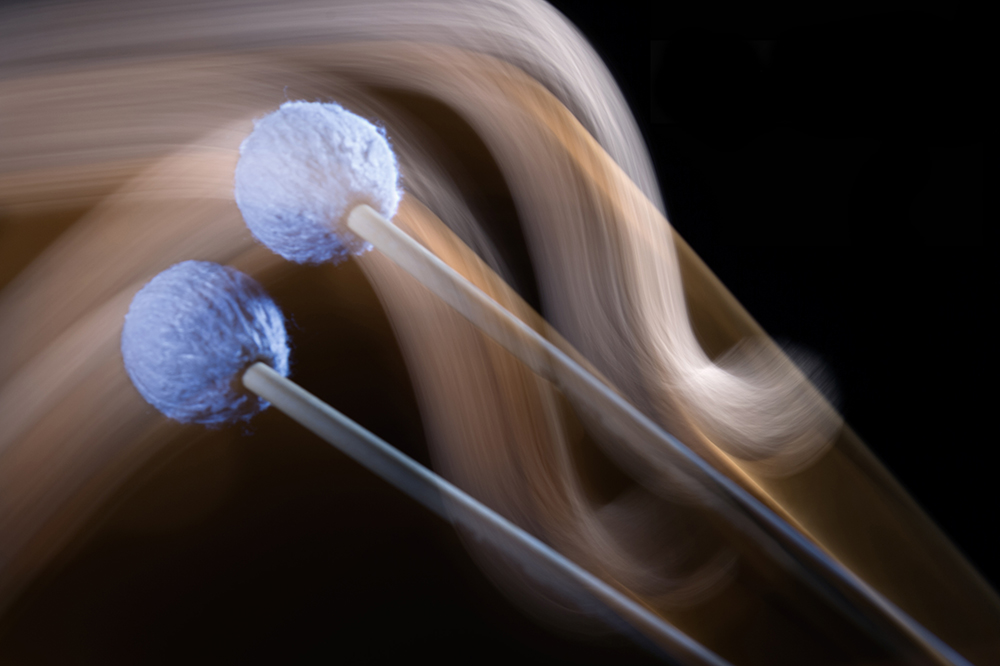 A motion blur of two percussion mallets