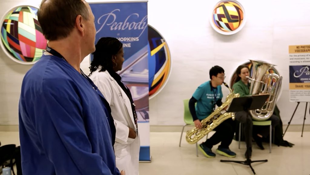 Brass musicians perform in a hospital public space